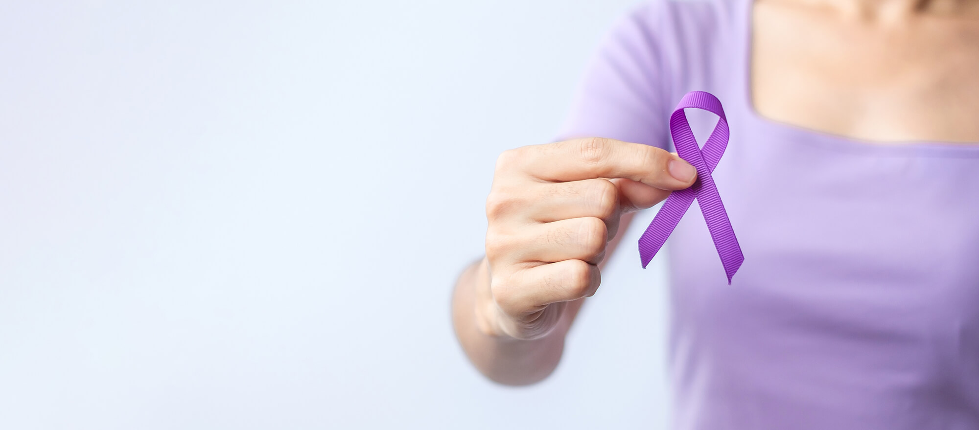 September is National Recovery Month. Image shows hand holding purple ribbon