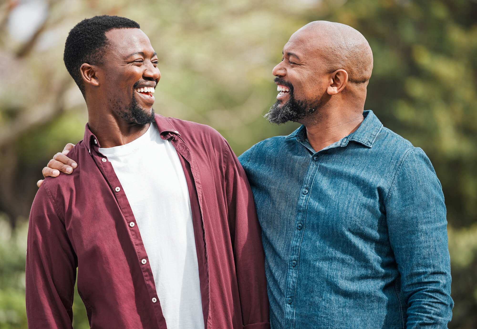 rebuilding-trust-relationships-addiction-recovery-gibson-center-2 Two men smiling and laughing together outdoors, representing the rebuilding of trust and connection between loved ones during addiction recovery